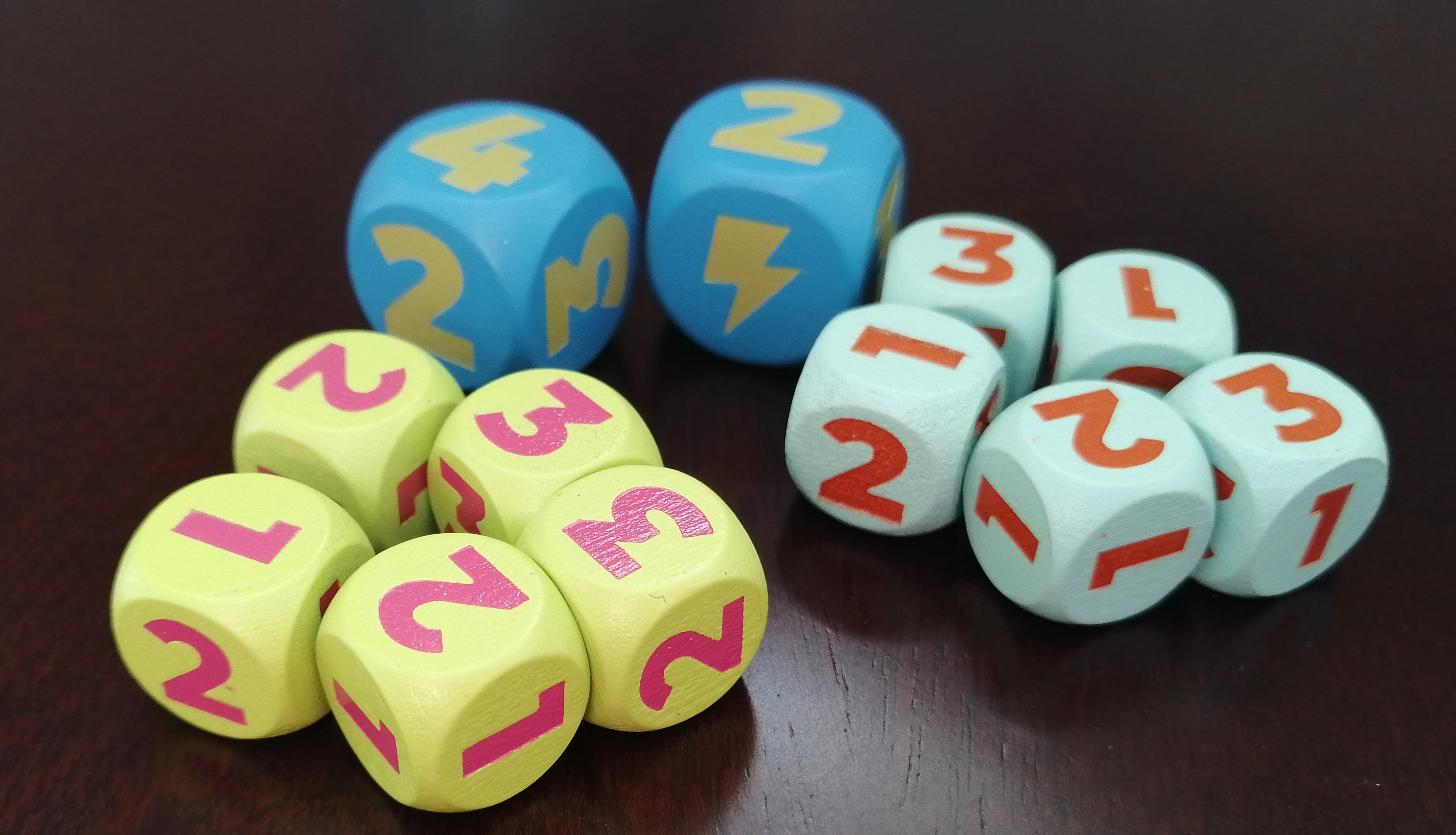 A selection of dice from Joyride, showing large numbers from 1 to 3. Two large nitro dice are in the back, which include a lightning bolt icon and a 4.
