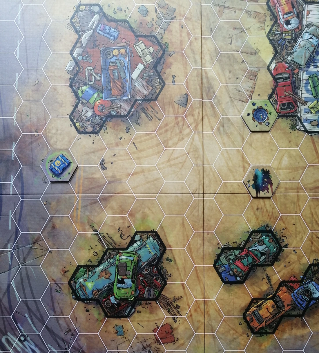 A photo of the board with some item tokens placed on it; a mine, an oil slick and an item box. The item tokens somewhat blend in to the background as their art mimics the dirt floor of some of the maps.