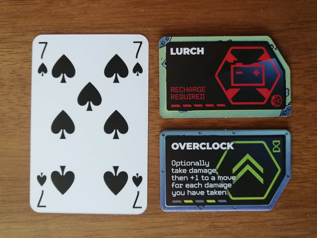 Ability tokens next to a standard playing card. The tokens are just under half the height of the card and slightly wider than the card.