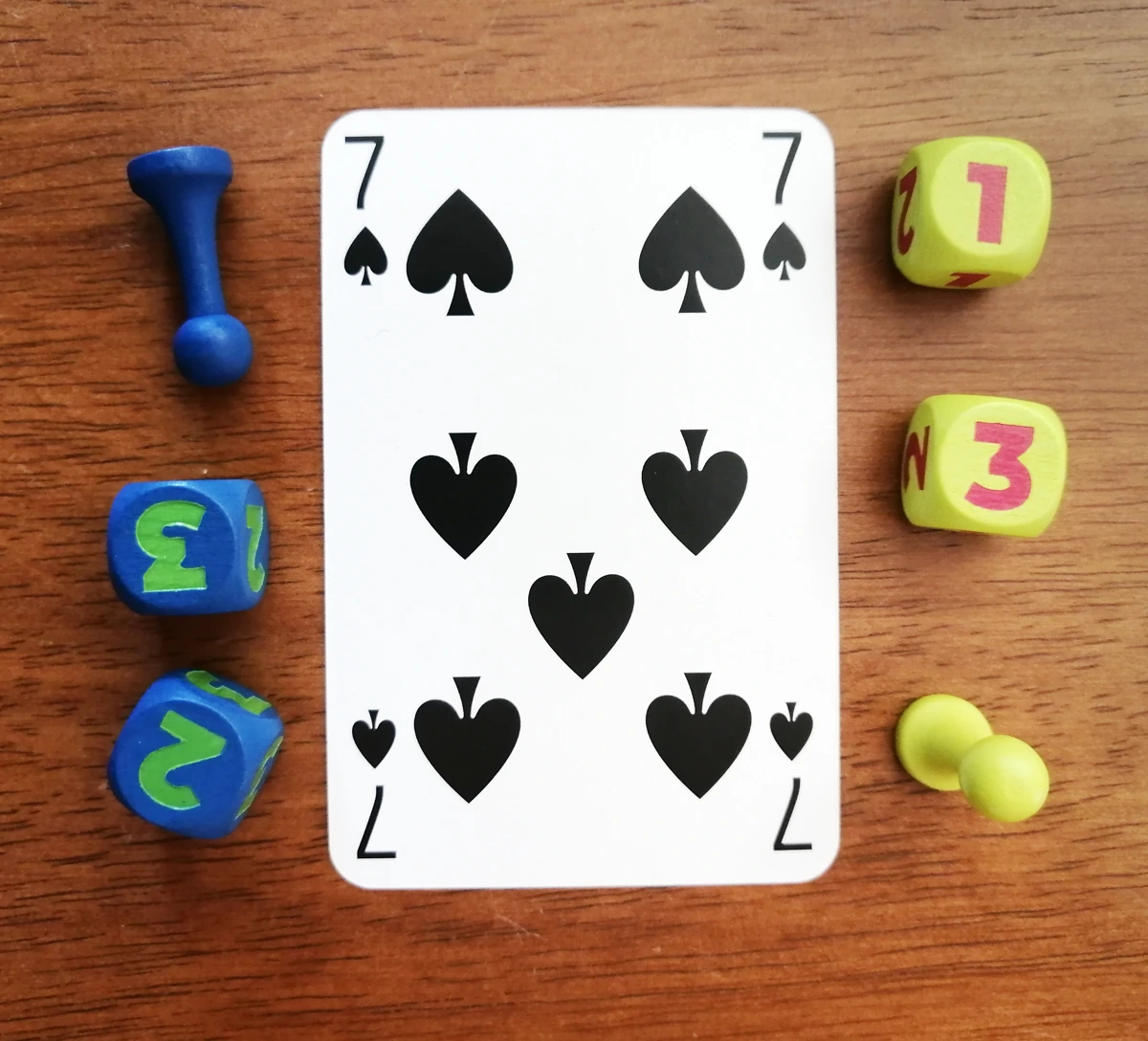 Dice and gear tokens next to a standard playing card. The dice are 16mm and the gear stick tokens are just under a third of the height of the card, with a very small base.